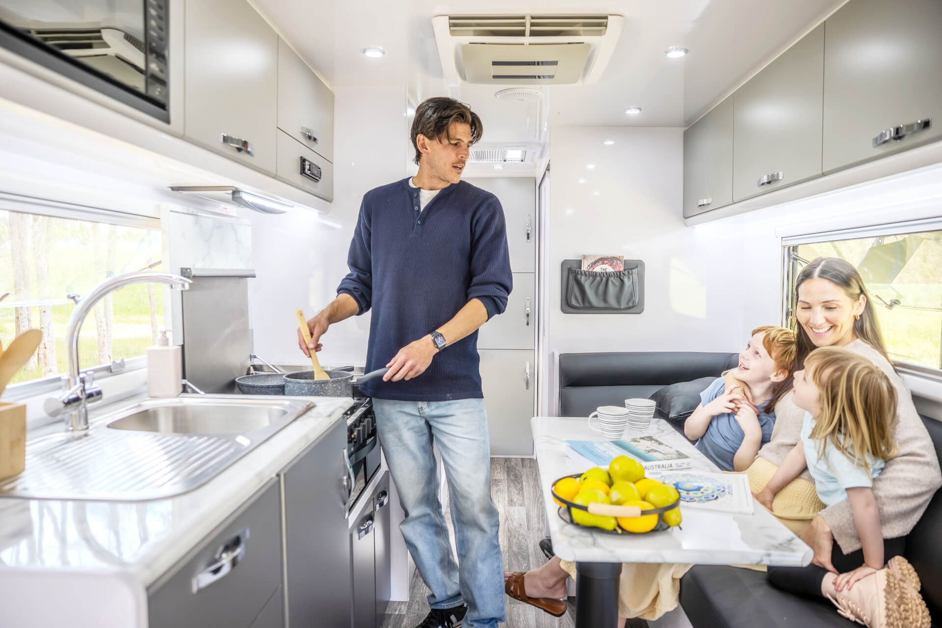 Family inside a Snowy River multi-terrain caravan kitchen
